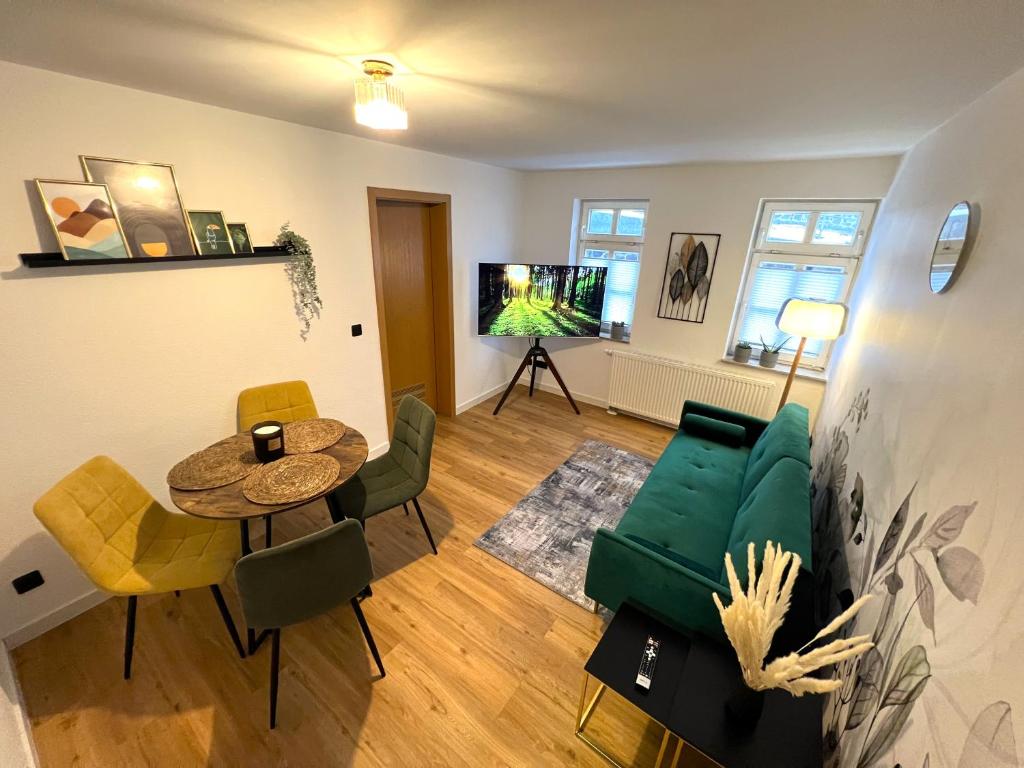 a living room with a green couch and a table at Apartments Dombergblick - Suhl, Stadtmitte in Suhl