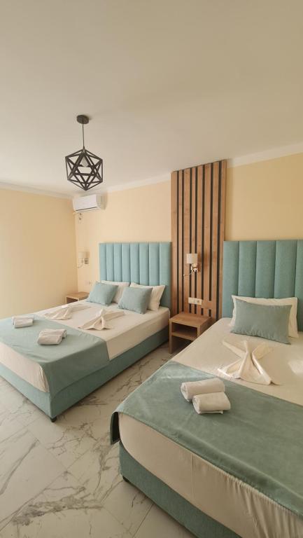 two beds in a large room with at Hotel Monte Mare - all inclusive in Čanj