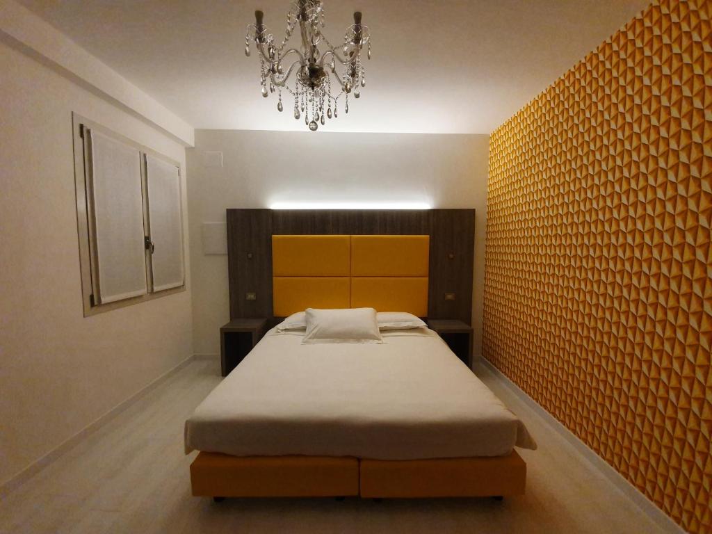 a bedroom with a bed and a chandelier at Al Santuario in San Vito al Tagliamento