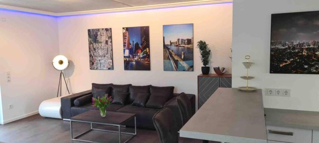 a living room with a couch and some pictures on the wall at stylish luxus appartments in the city center in Trier