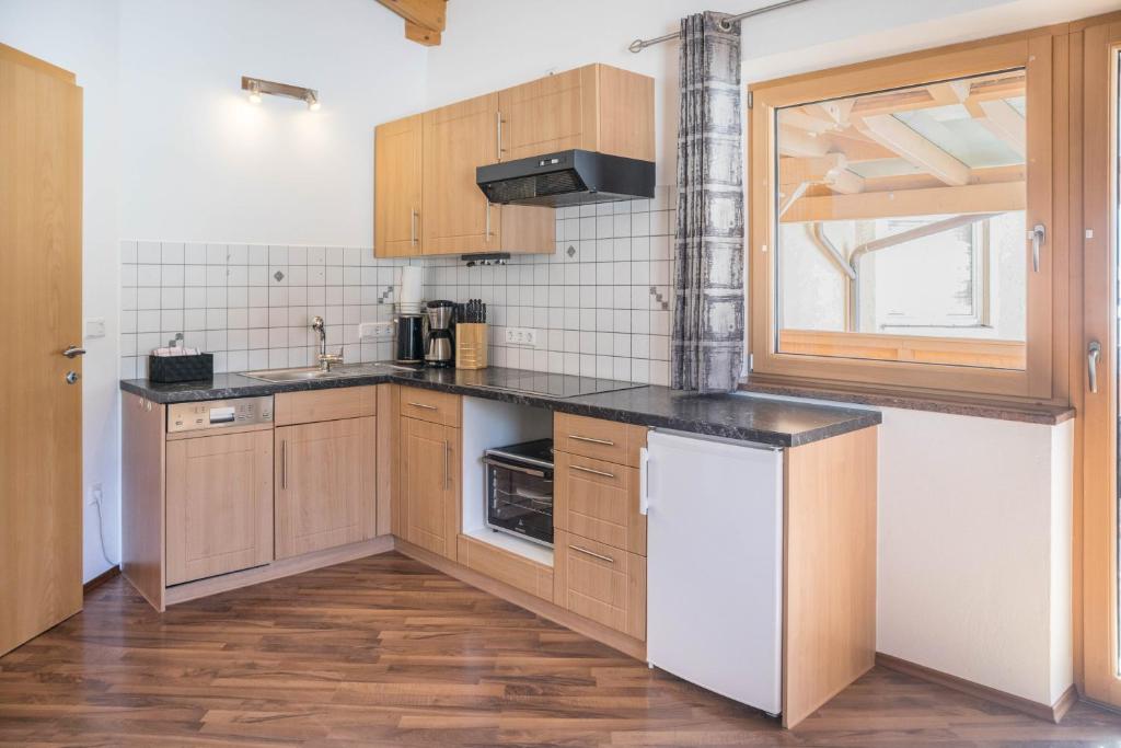 a small kitchen with wooden cabinets and a window at Appartement Julia in Achenkirch