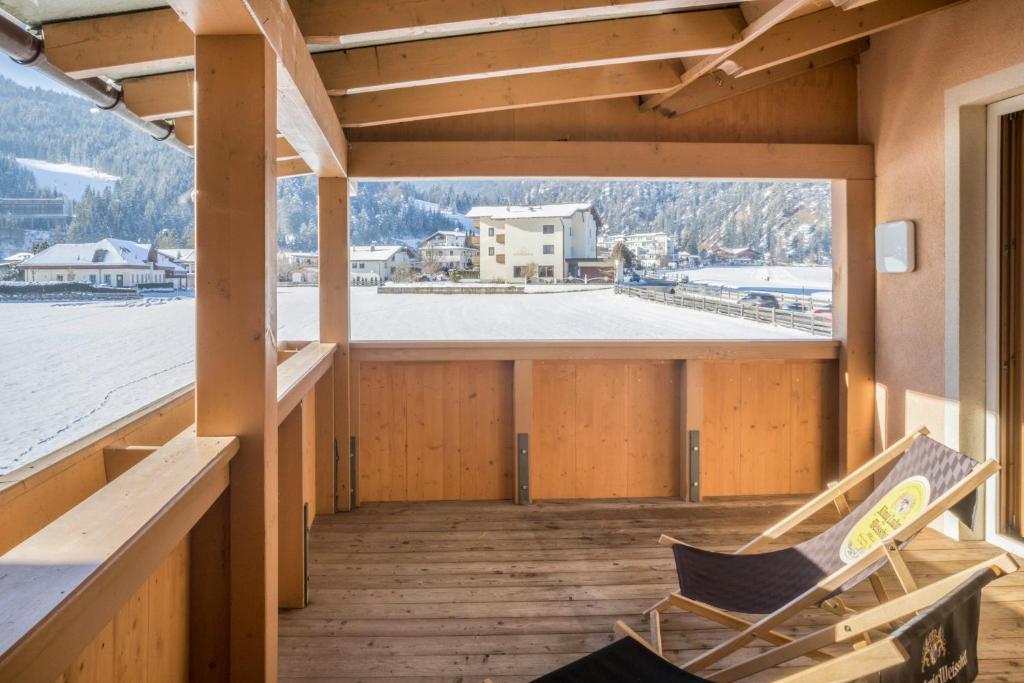 a room with two chairs on a deck with a view at Appartement Julia in Achenkirch