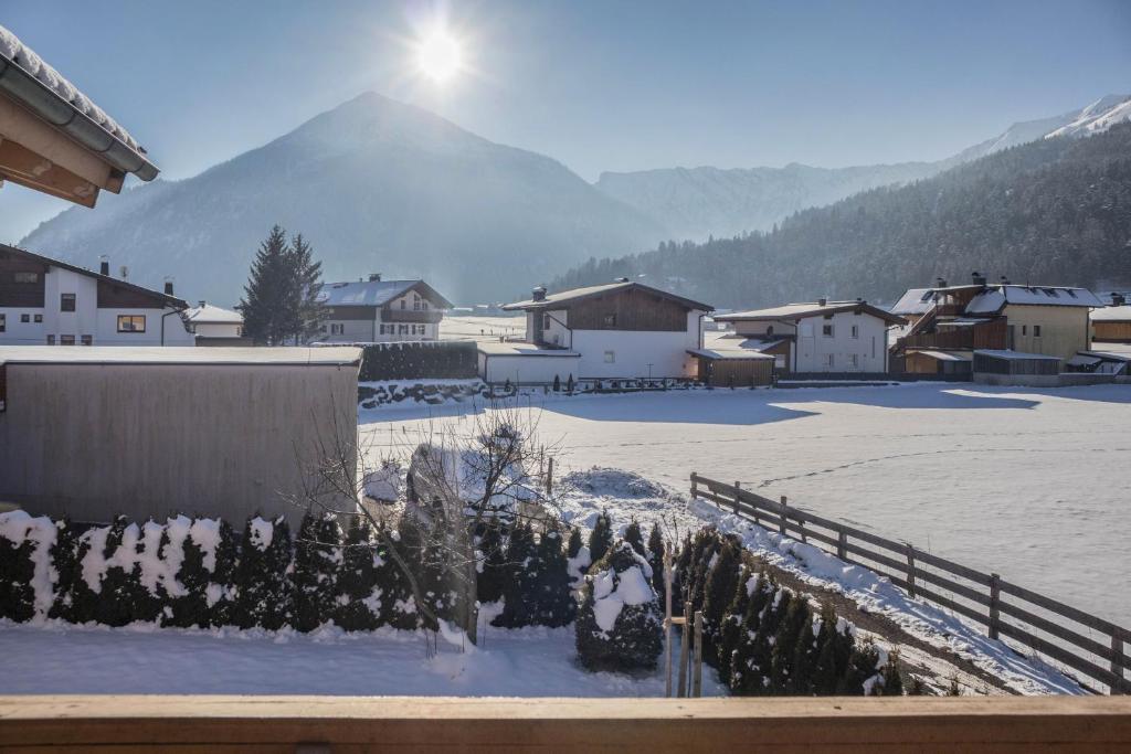 a snow covered village with a mountain in the background at Appartement Julia in Achenkirch