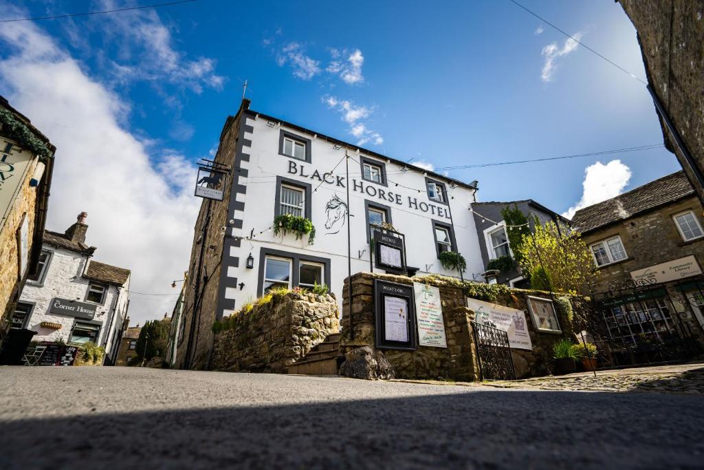 een wit gebouw aan de straatkant bij Black Horse Hotel in Grassington