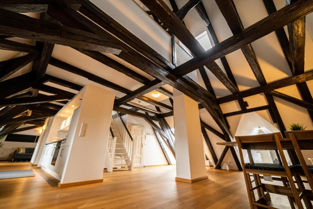 a room with exposed beams and wooden floors at The FULL HOUSE Loft in Halle an der Saale