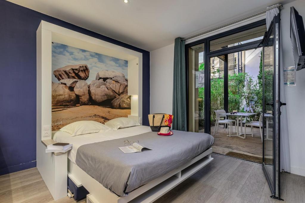 a bedroom with a bed with a painting on the wall at Belambra Clubs Presqu&#39;île De Giens - Riviera Beach Club in Hyères