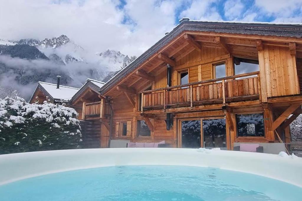 a log house with a swimming pool in front of it at Les Drus - Luxury Chalet for 8 in Chamonix-Mont-Blanc