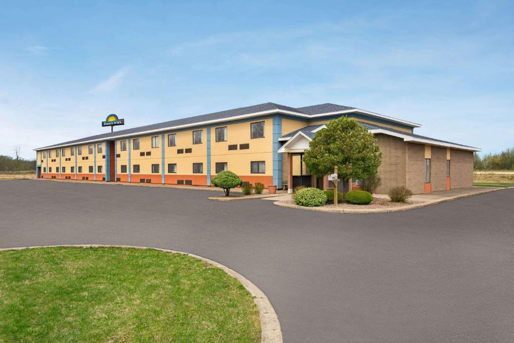 a rendering of a large building with a parking lot at Days Inn by Wyndham Canastota Verona in Canastota
