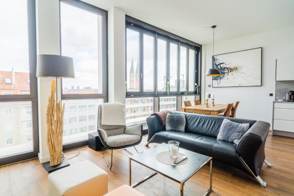 a living room with a couch and a table at Panorama Bliss - Luxus Apartment in Braunschweig's Altstadt in Braunschweig