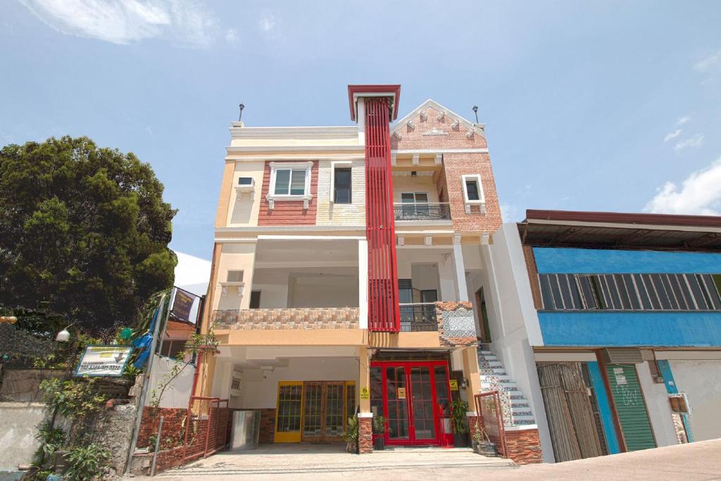 un edificio con una puerta roja en una calle en OYO 685 K Fortune Apartelle en Isla de Mactán