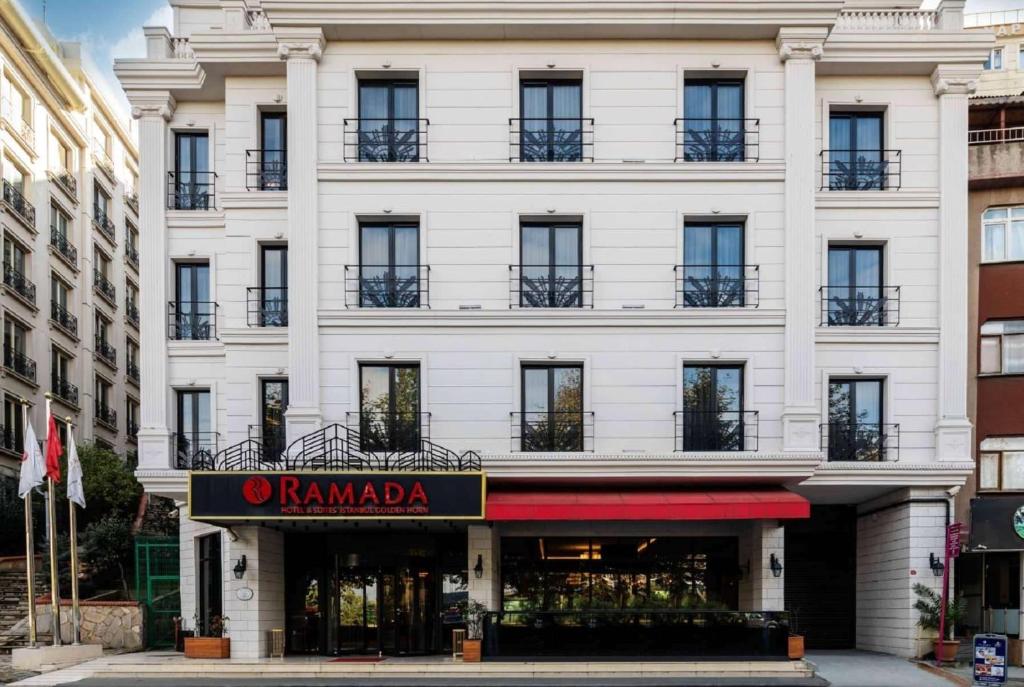 a large white building with a store in front of it at Ramada by Wyndham Istanbul Golden Horn in Istanbul
