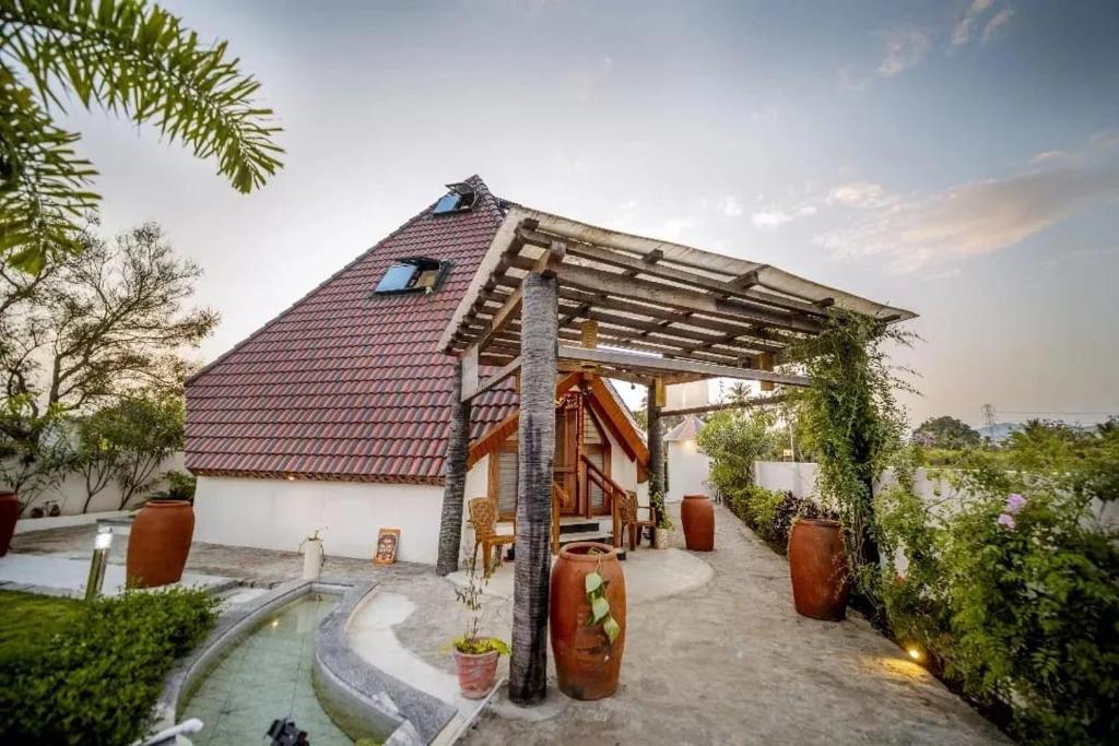 een huis met een gambrel dak en een patio bij susil house villa in Vellore