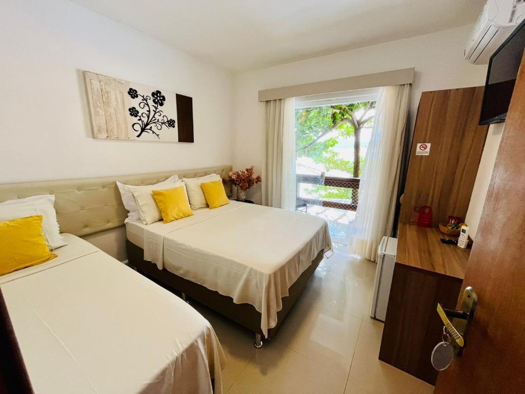 ニテロイにあるPousada Camarote Itaipuのベッド2台と窓が備わるホテルルームです。