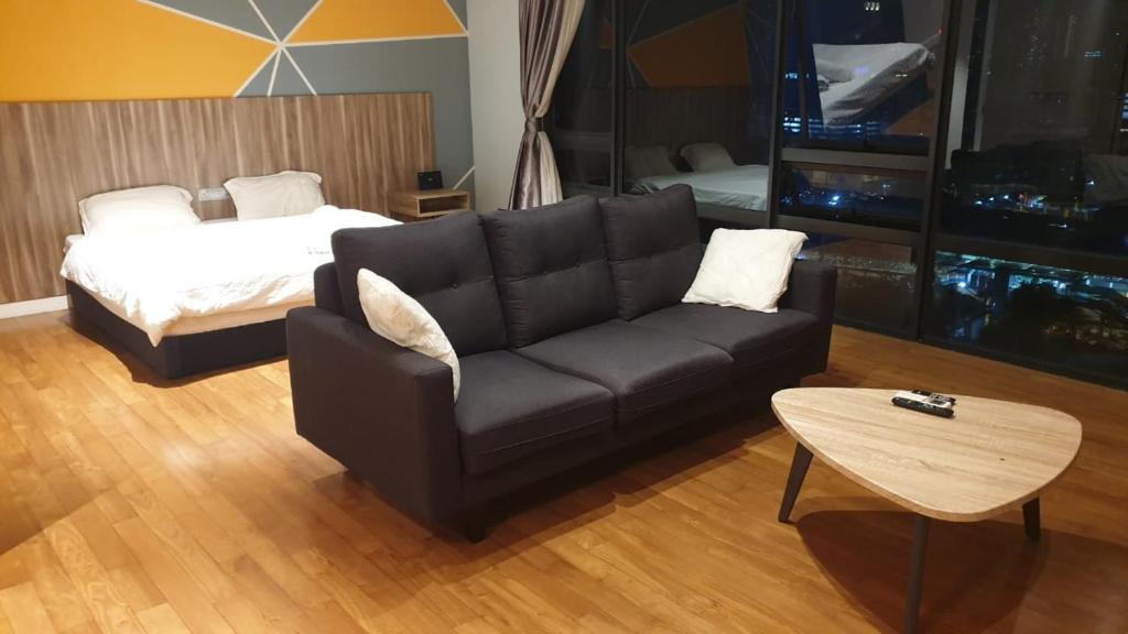 a living room with a couch and a bed at Anggun Residences Luxe in Kuala Lumpur