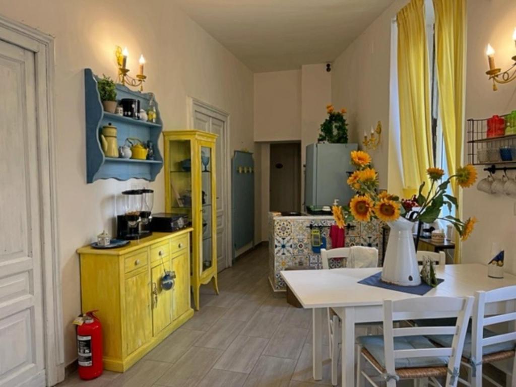 eine Küche mit gelben Schränken und einem Tisch mit Stühlen in der Unterkunft Napoli Da Vivere Suites Giudecca in Neapel