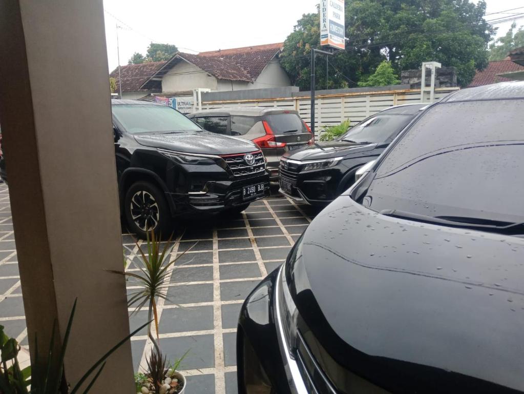una fila de autos estacionados en un estacionamiento en CALDERA PARK HOMESTAY Syariah en Probolinggo