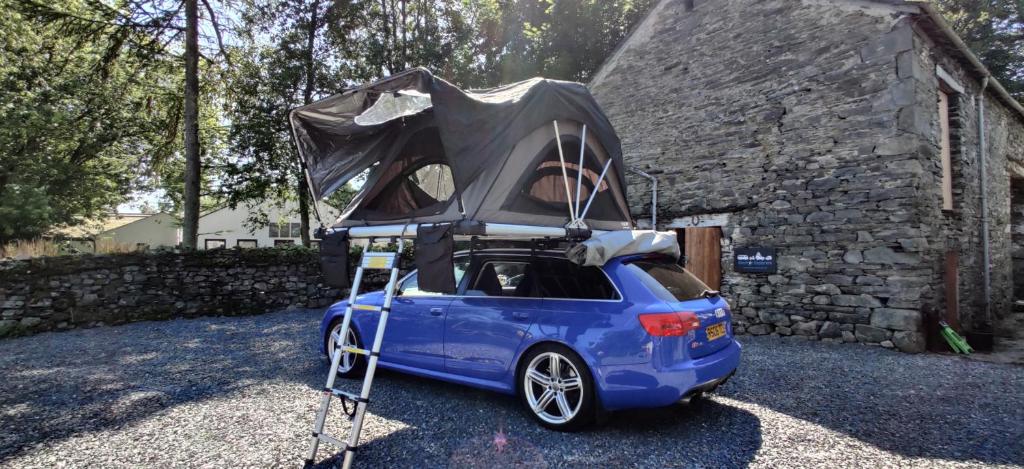 a small blue car with a camper on top of it at Shackleton Rooftop Tent Rental from ElectricExplorers in Hawkshead