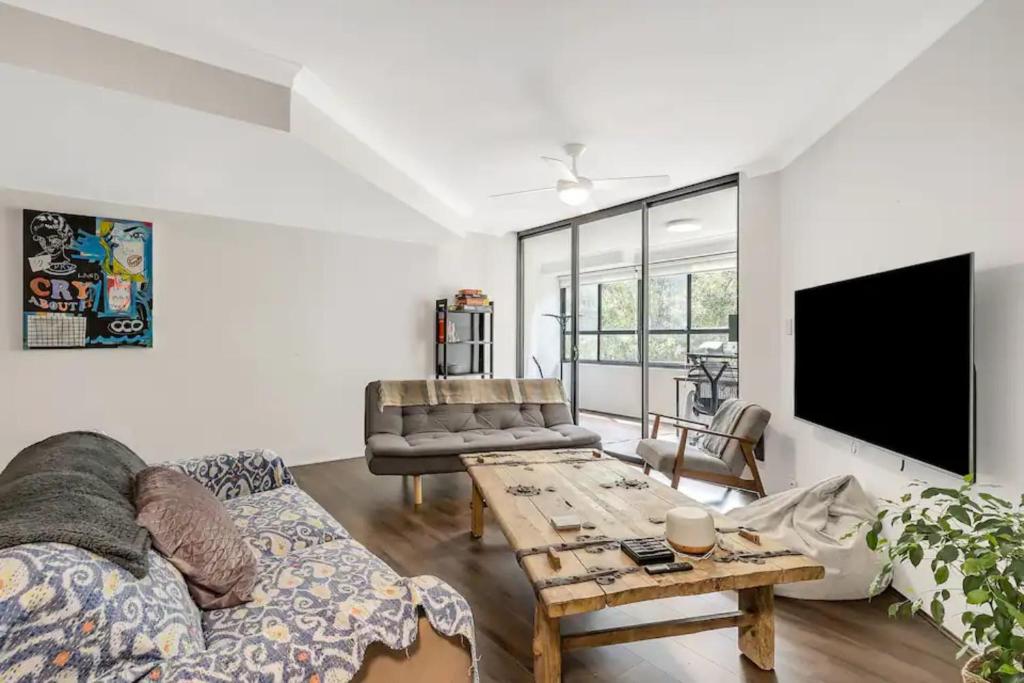 a living room with a couch and a table at Spacious 1 Bedroom Apartment near Newtown in Sydney