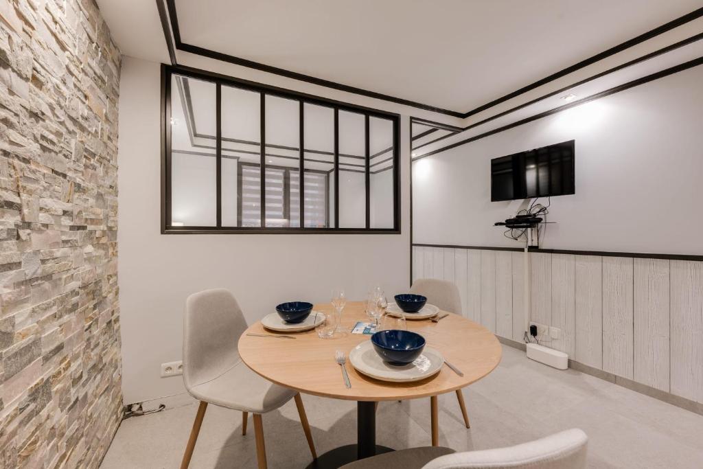 une salle à manger avec une table et des chaises en bois dans l'établissement Chaleureux plein centre ville et proche du Lac, à Annecy