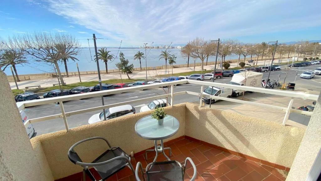 a balcony with a table and chairs and a parking lot at Rhode 1b in Roses