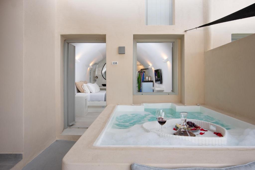 a bath tub with a glass of wine in a room at BlackRock suites in Karterados