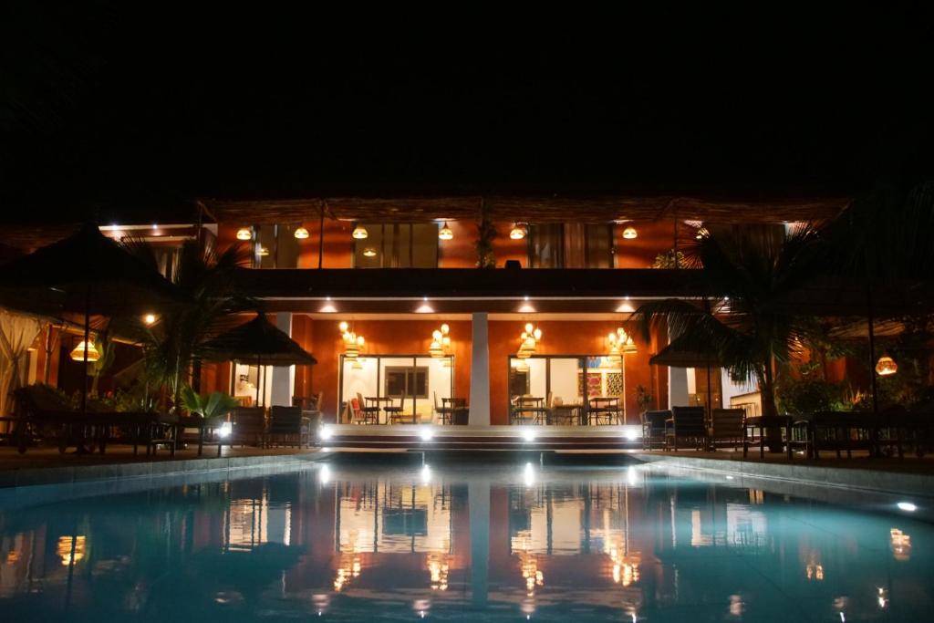 a swimming pool in front of a building at night at Maison de clara in Ngaparou