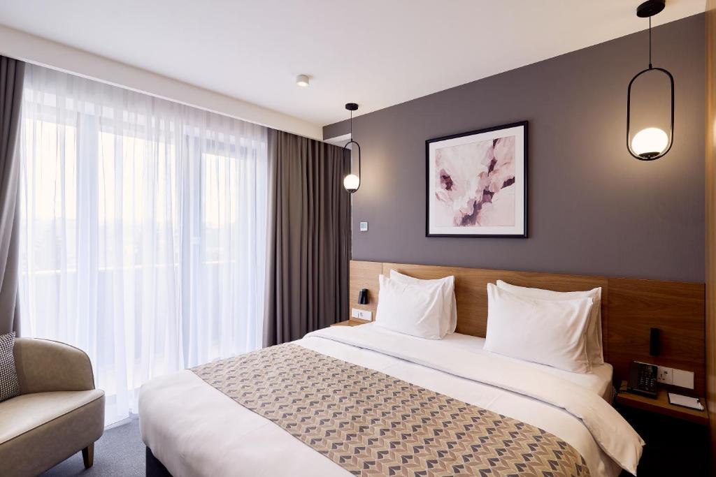 Postel nebo postele na pokoji v ubytování Clocks Hotel Tbilisi
