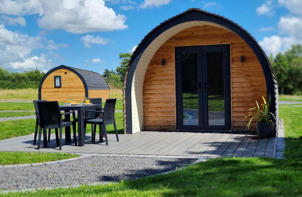 a gazebo with a table and chairs on a patio at Habberley Glamping Pods in Shrewsbury