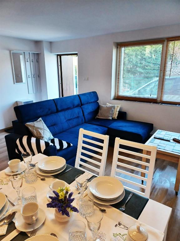 a living room with a table and a blue couch at Apartament LABA in Sosnówka