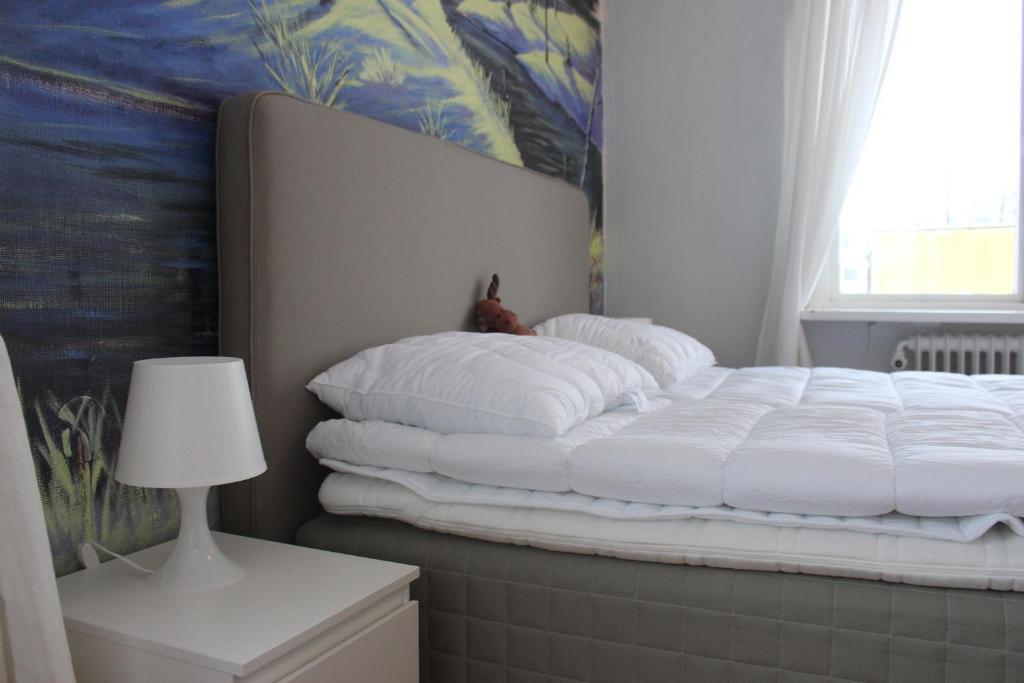 een bed met witte kussens in een kamer bij Säfsen Stay in Ludvika