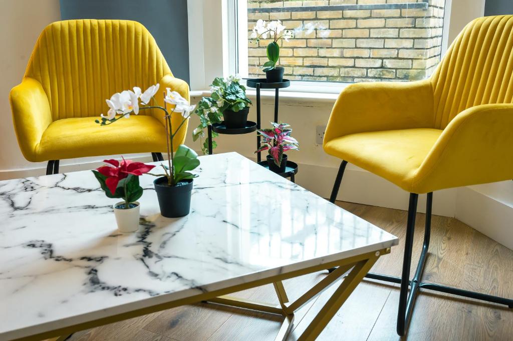 2 sillas amarillas y una mesa de centro en la sala de estar. en Stylish 2 Bedrooms Little Venice - 44, en Londres