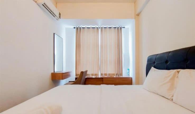 een slaapkamer met een groot wit bed en een raam bij Lavender basura in Jakarta