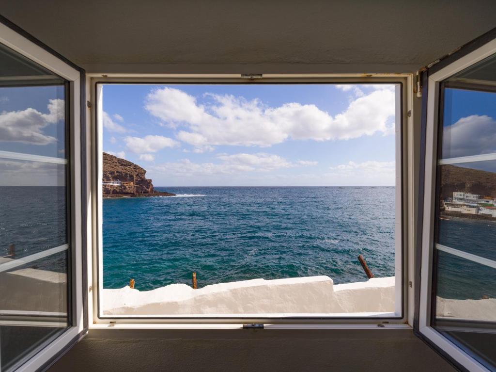 una ventana con vistas al océano desde un barco en HomeForGuest Listen to the Ocean in Tufia en Telde