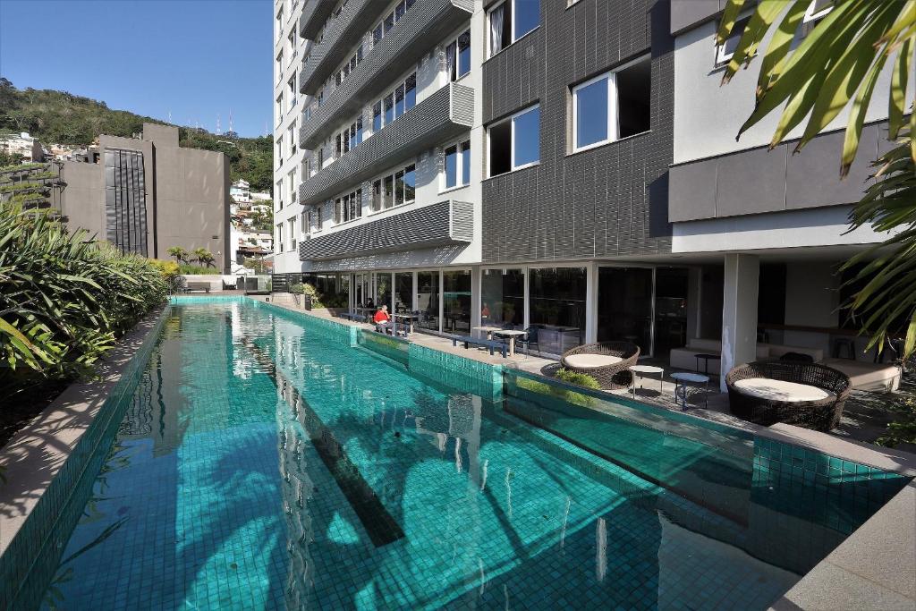 a large swimming pool next to a building at Patio Milano Apartamentos completos em condominio incrivel com food hall in Florianópolis