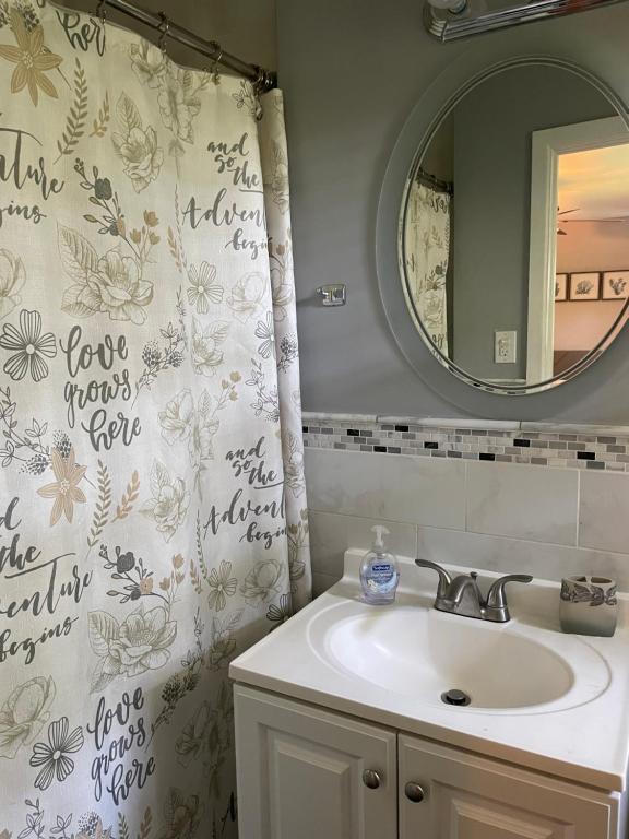 La salle de bains est pourvue d'un lavabo et d'un miroir. dans l'établissement Spacious single family home close to VA and DC 5mins to MGM, à Fort Washington