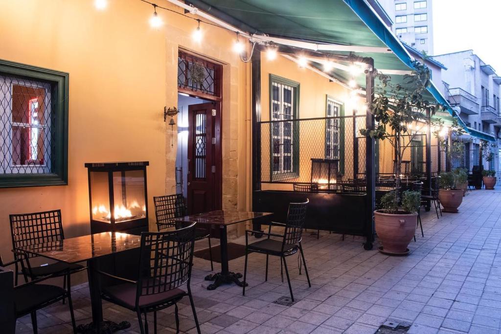 patio restauracji ze stołami i krzesłami w obiekcie Madama Residence w Nikozji