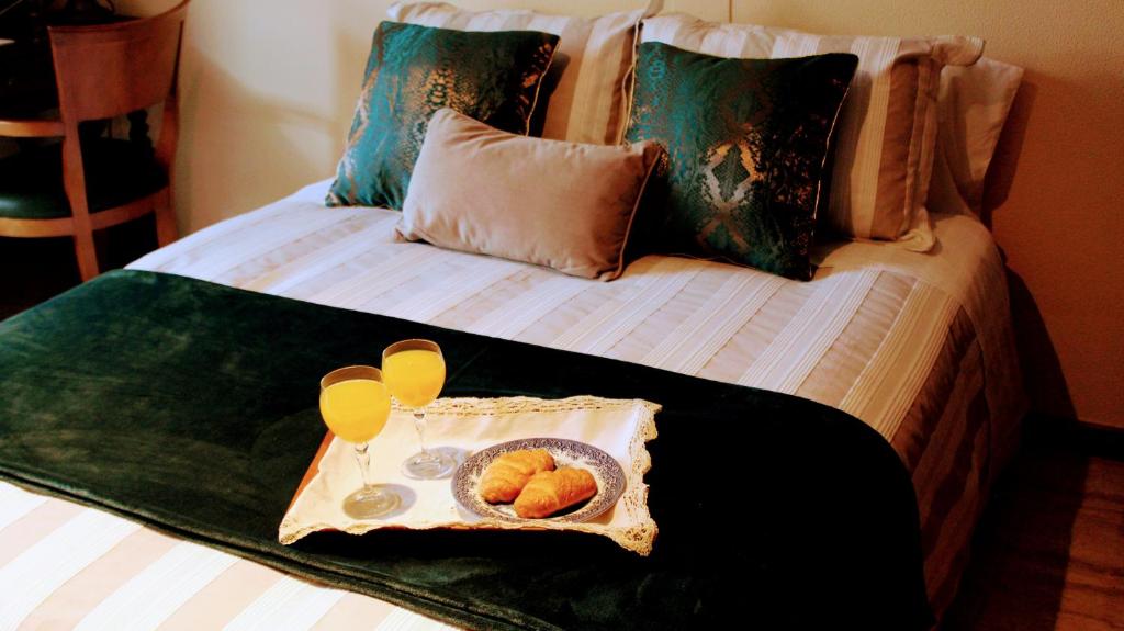 a bed with a tray with a plate of food on it at O fogar de Susana in Baiona