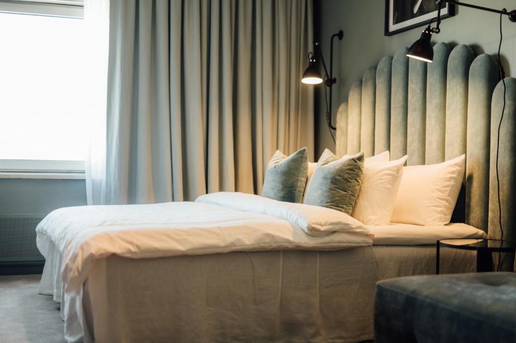 a bedroom with a large bed with white pillows at Quality Hotel Carlia in Uddevalla