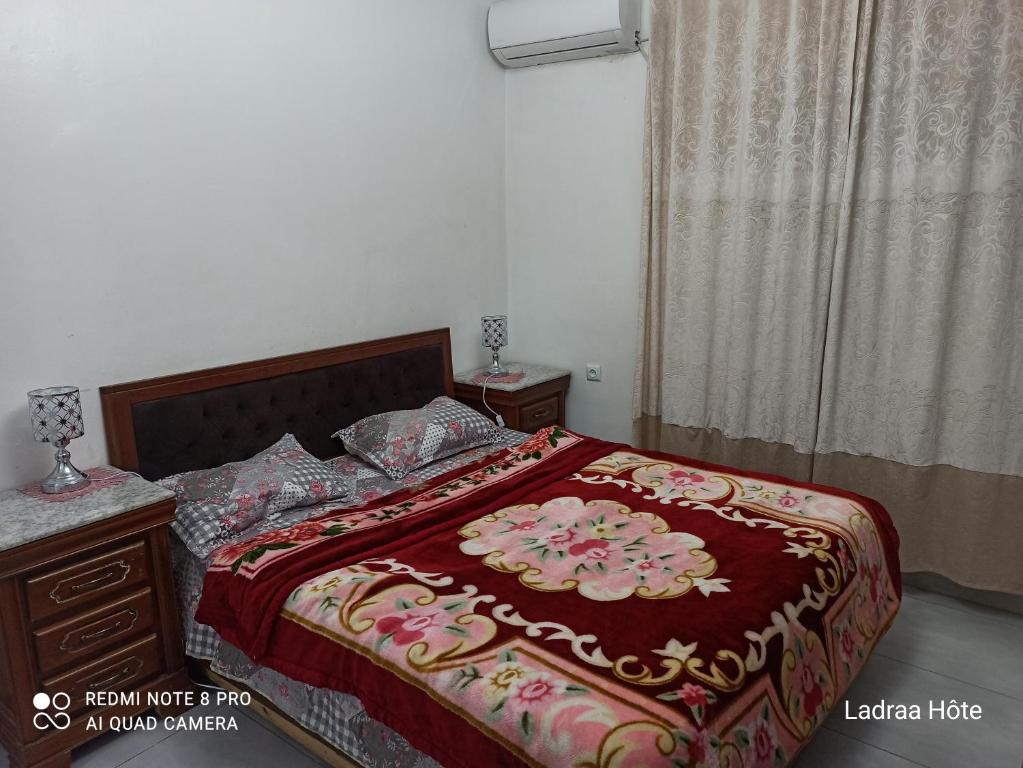 1 dormitorio con 1 cama grande con manta roja en عين النعجة جسر قسنطينة الجزائر Ain Naadja, 