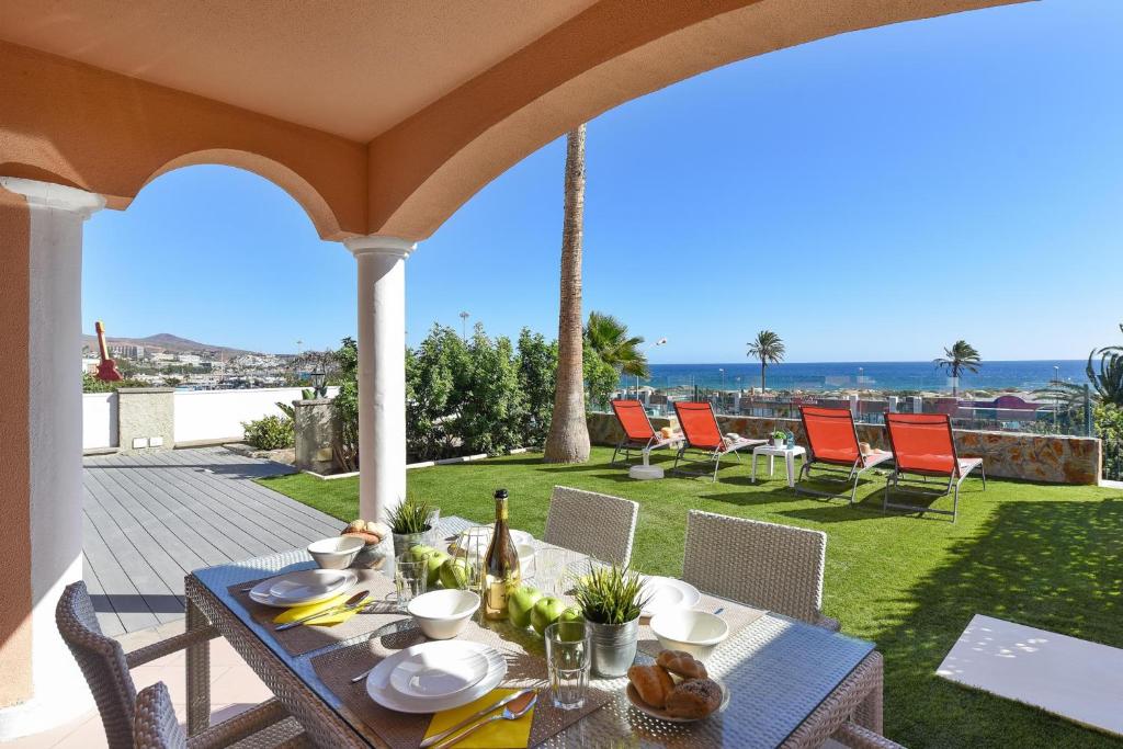una mesa en un patio con vistas al océano en Chalet Santa Ana 2 by VillaGranCanaria en Playa del Ingles