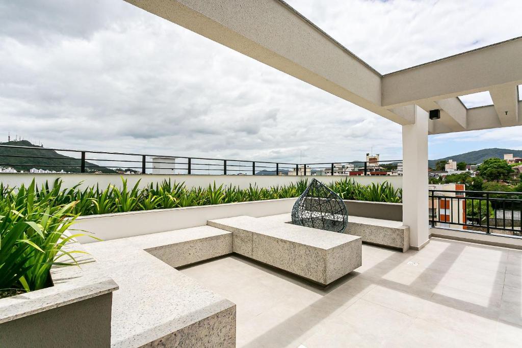 eine Terrasse mit einer Bank auf dem Balkon in der Unterkunft Apartamentos completos ao lado da UFSC - NAVONA in Florianópolis