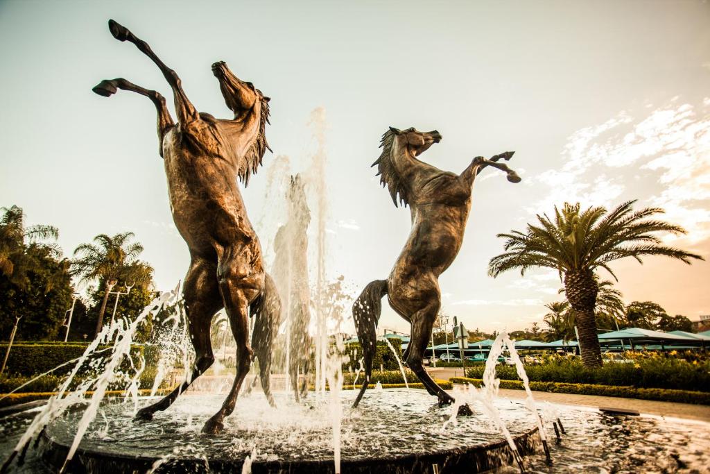 a fountain with three mermaids jumping in the water at Golden Horse Hotel 