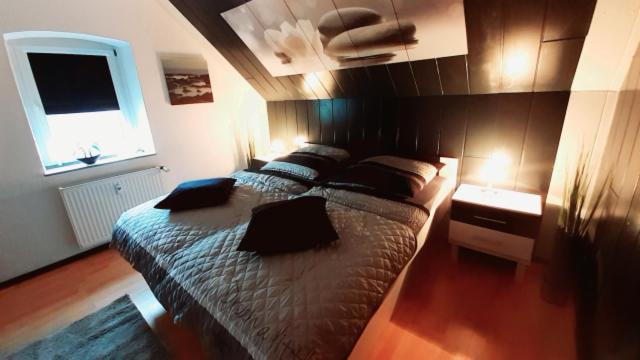 a bedroom with a large bed and a window at Ferienwohnung Am Vulkanpfad in Ettringen