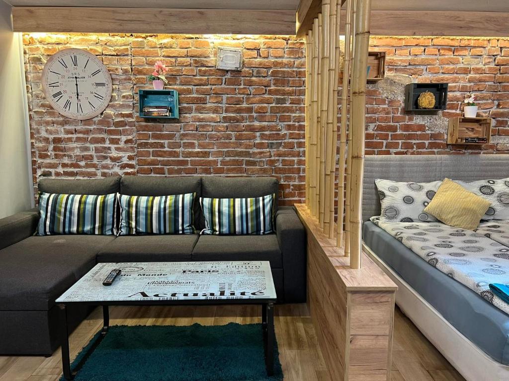 un soggiorno con divano e muro di mattoni di City Garden Studio a Plovdiv