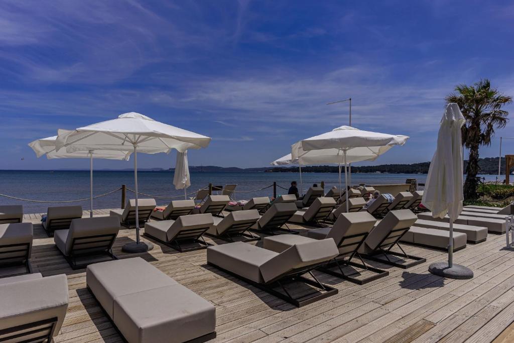 a bunch of chairs and umbrellas on a beach at Belambra Clubs Presqu&#39;île De Giens - Riviera Beach Club in Hyères