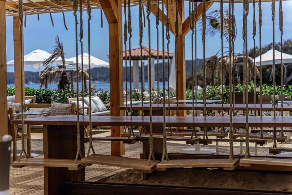 a group of tables in a pavilion with mountains in the background at Belambra Clubs Presqu&#39;île De Giens - Riviera Beach Club in Hyères