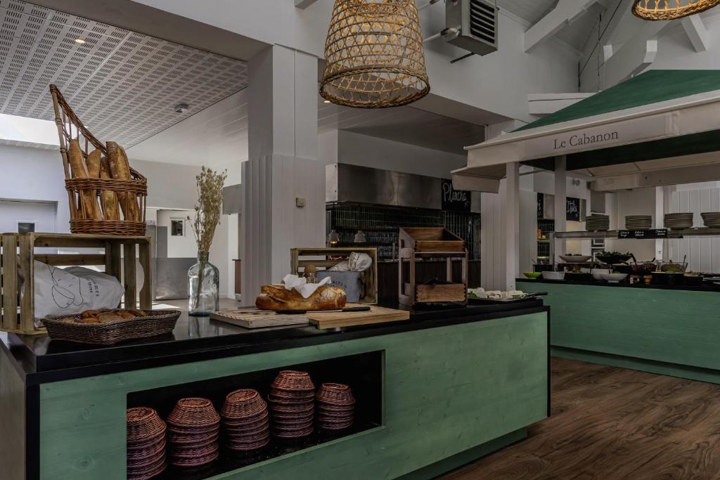 a kitchen with a counter with plates on it at Belambra Clubs Presqu&#39;île De Giens - Riviera Beach Club in Hyères