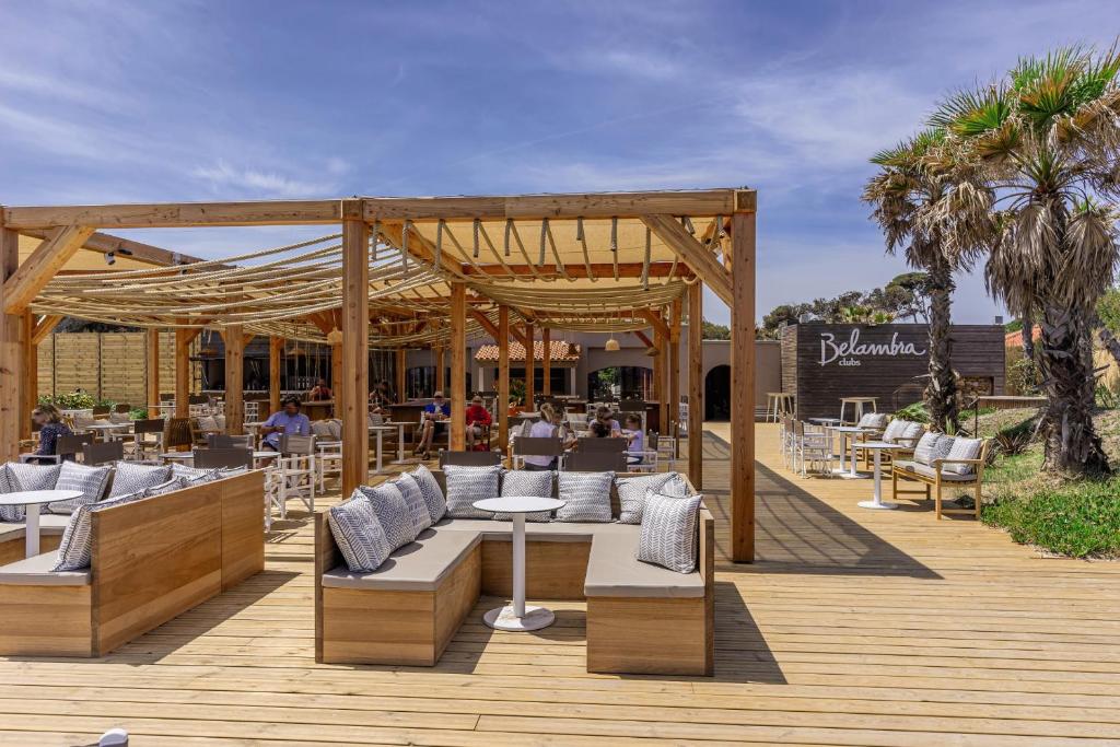 a restaurant with chairs and tables on a wooden deck at Belambra Clubs Presqu&#39;île De Giens - Riviera Beach Club in Hyères