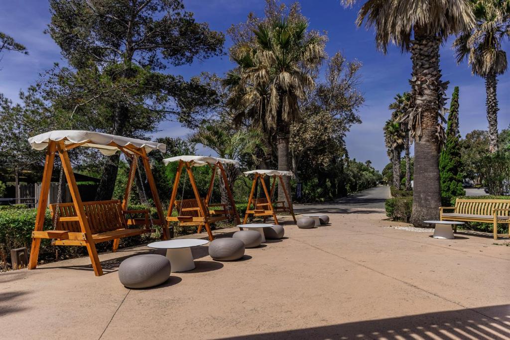 a park with benches and trees and palm trees at Belambra Clubs Presqu&#39;île De Giens - Riviera Beach Club in Hyères