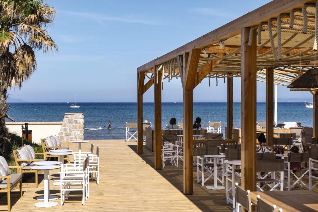 a boardwalk with tables and chairs on the beach at Belambra Clubs Presqu&#39;île De Giens - Riviera Beach Club in Hyères